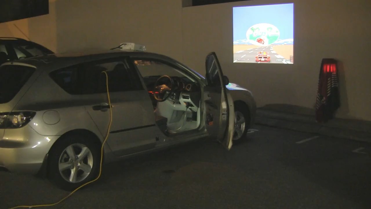 An earlier version of the plan involved using the the horn as a fire button, but I like this building and didn't feel the need to get evicted just yet A car rigged to play videogames with a projector pointed at a wall